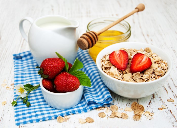 Still life of muesli, strawberries, honey, and milk