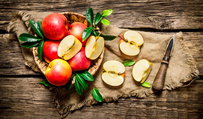 Apples in a basket on a wooden table