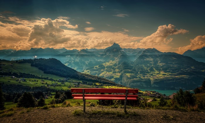 Red bench overlooking Swiss mountains and lake