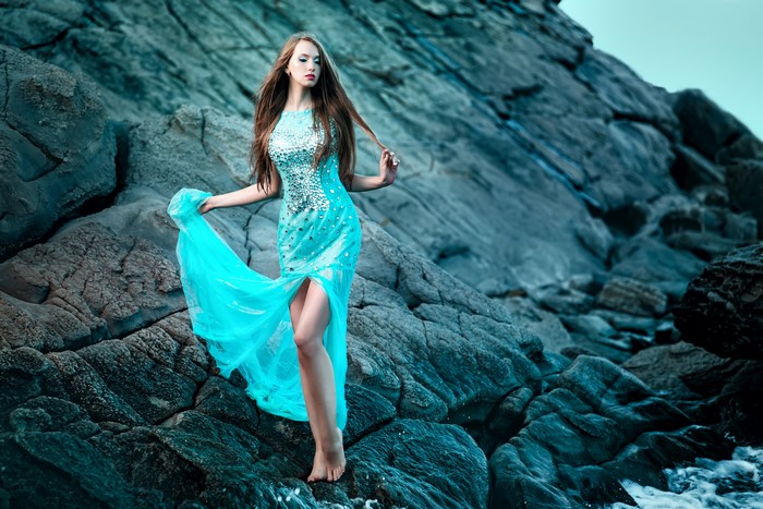 Woman in a blue dress on rocks