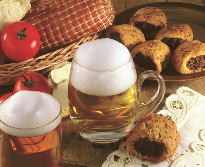 Beer and pastries with ham and tomatoes