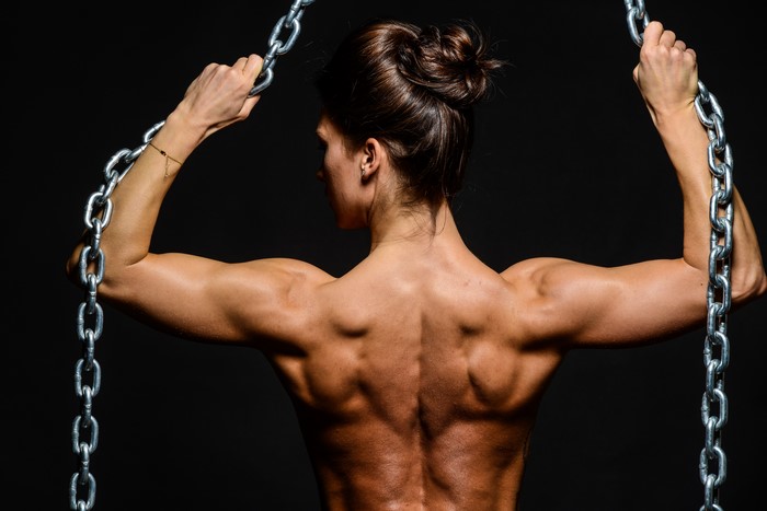 Woman with muscular back holding chains