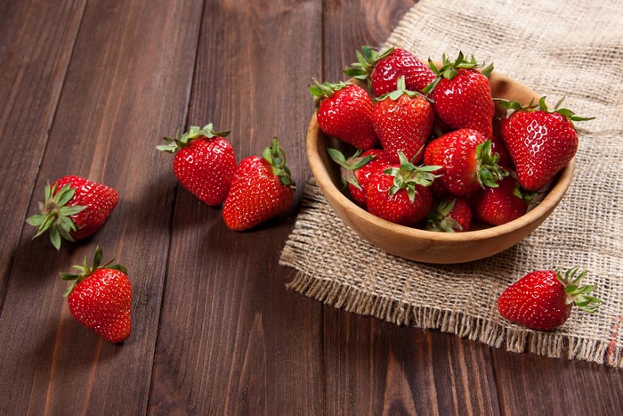 Strawberries in a bowl on a wooden table