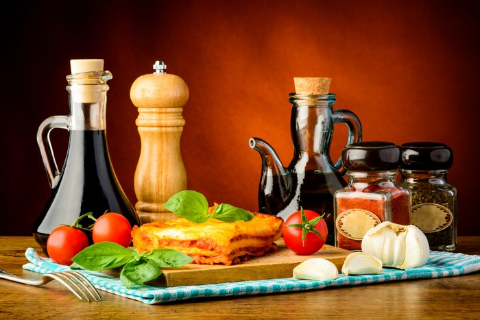 Still life with lasagna, tomatoes, garlic, and oils