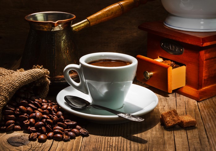 Coffee cup with cezve, coffee grinder, and beans