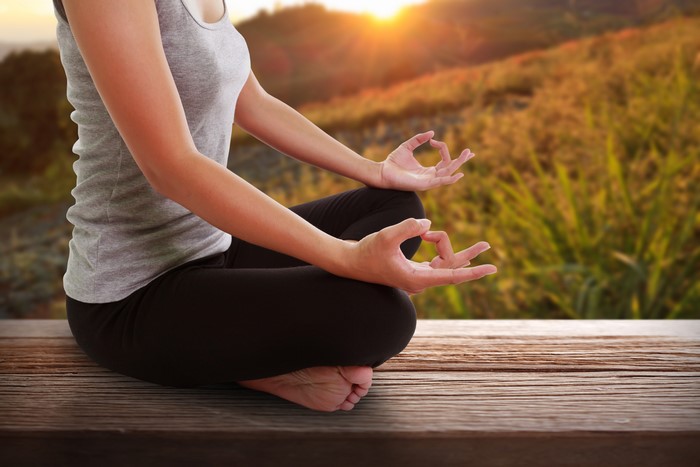 Woman meditating in Lotus position outdoors