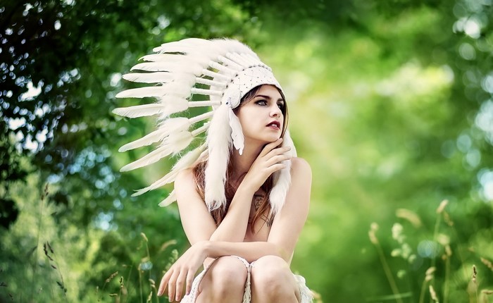 Woman wearing a white feather headdress outdoors