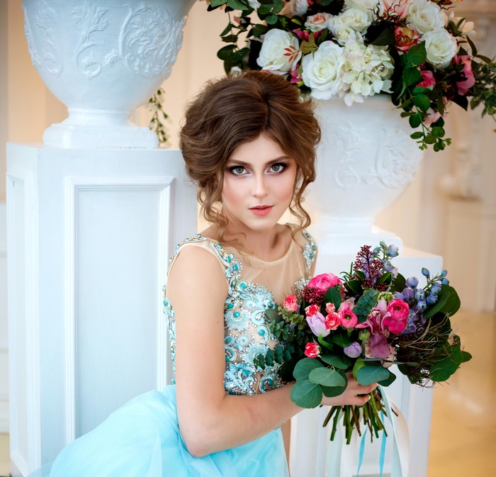 Woman in blue dress holding a bouquet
