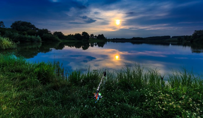 Fishing rod by a lake at sunset