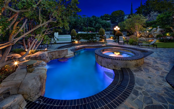 Luxury backyard pool and spa at night
