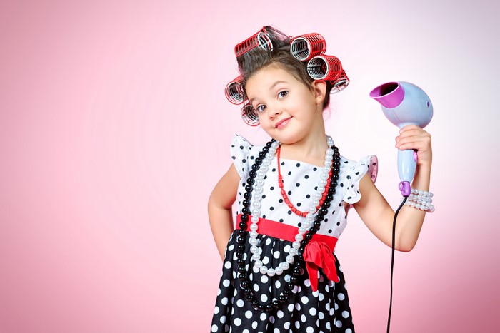 Little girl with hair curlers and hairdryer