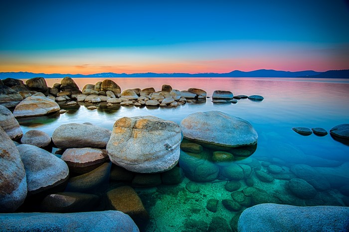 Stones on the shore of a lake at sunset