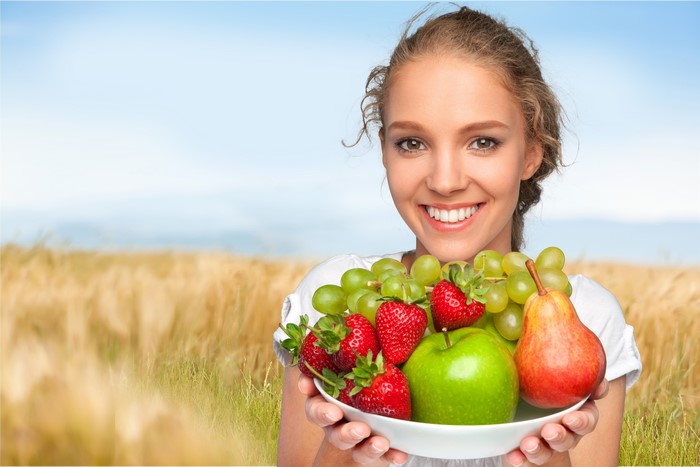 Woman holding a plate of fruit