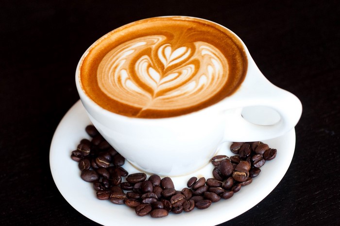 Latte art coffee cup with coffee beans