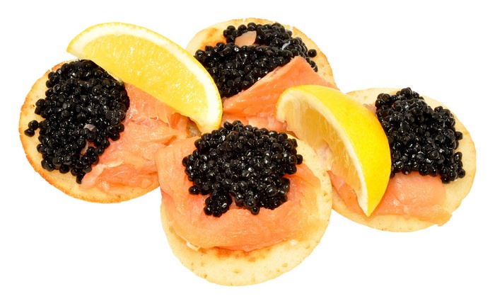 Caviar and smoked salmon on crackers with lemon