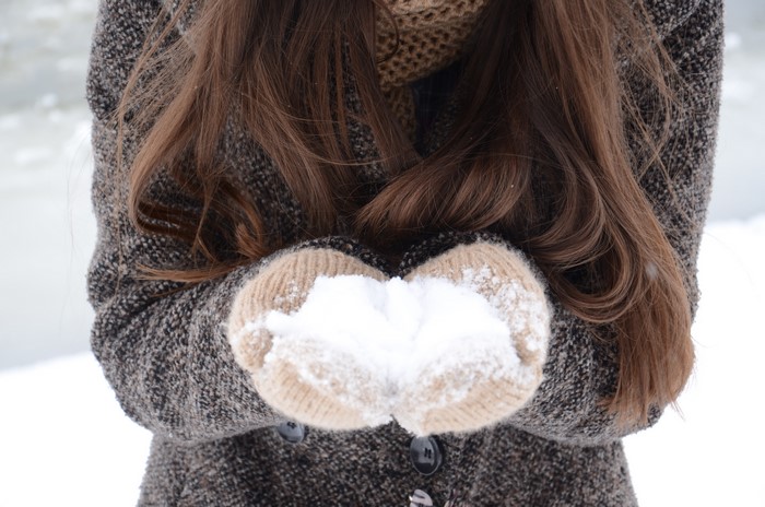 Woman holding snow in mittens