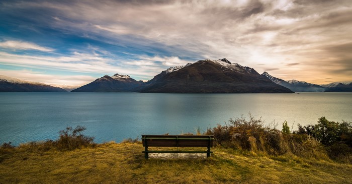 Bench overlooking mountains and lake in Queenstown, New Zealand