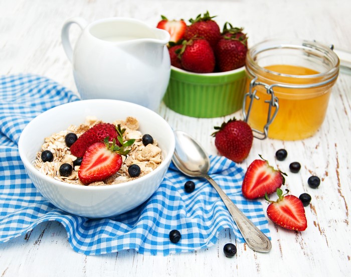 Still-life of muesli with strawberries, blueberries, and honey