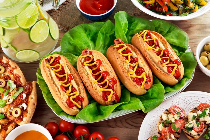 Hot dogs with ketchup and mustard on lettuce