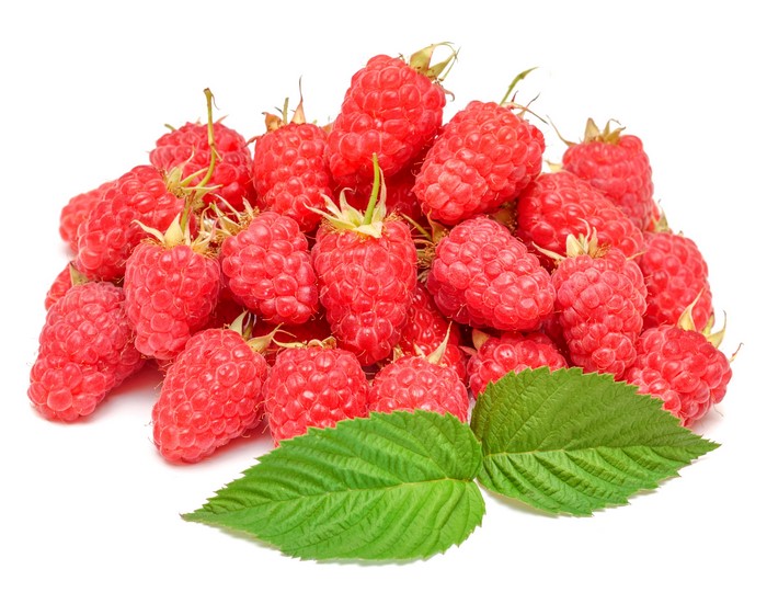 Pile of fresh raspberries with green leaves