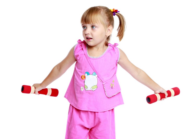 Little girl with dumbbells on white background