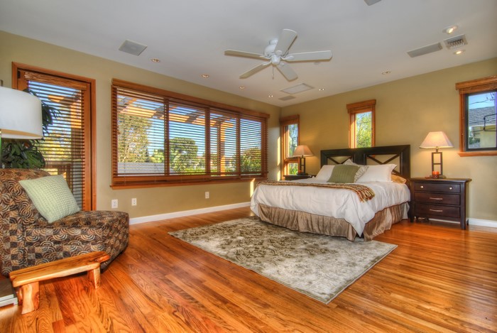 Bedroom with bed, armchair, and large windows