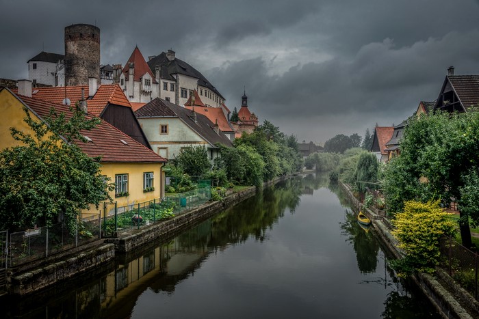Houses along a canal with a castle in the background