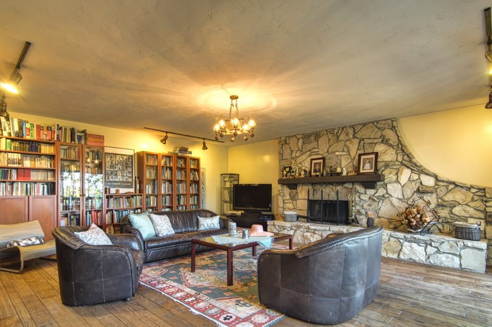 Living room with fireplace, sofa, and bookshelves