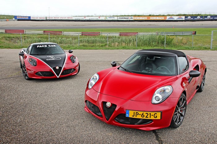 Two red Alfa Romeo 4C Spider cars on a race track