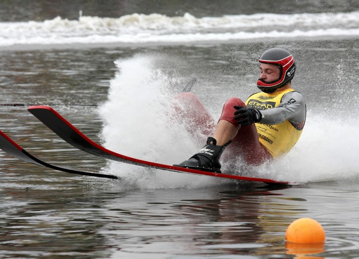 Man water skiing with helmet and red suit