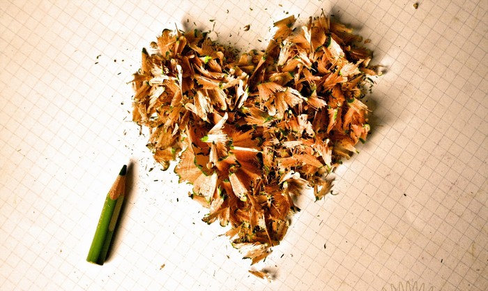 Heart shape made of pencil shavings with a green pencil