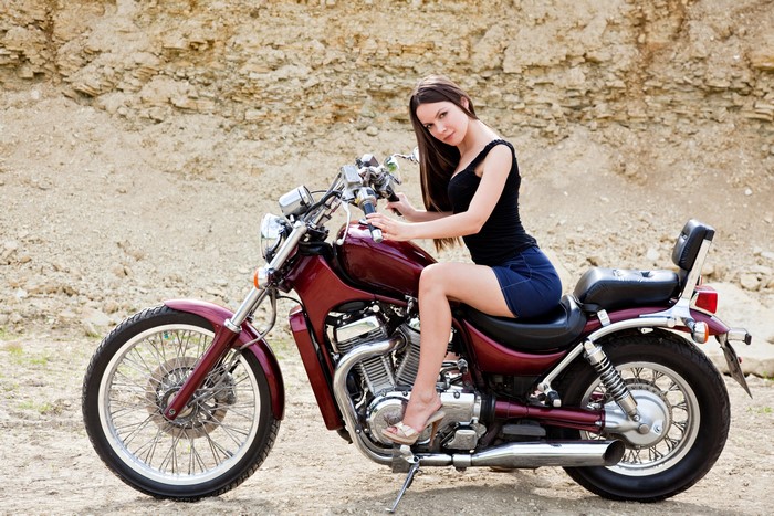 Brown haired woman sitting on a motorcycle