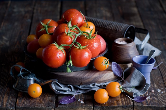 Tomatoes and vegetables on a wooden table