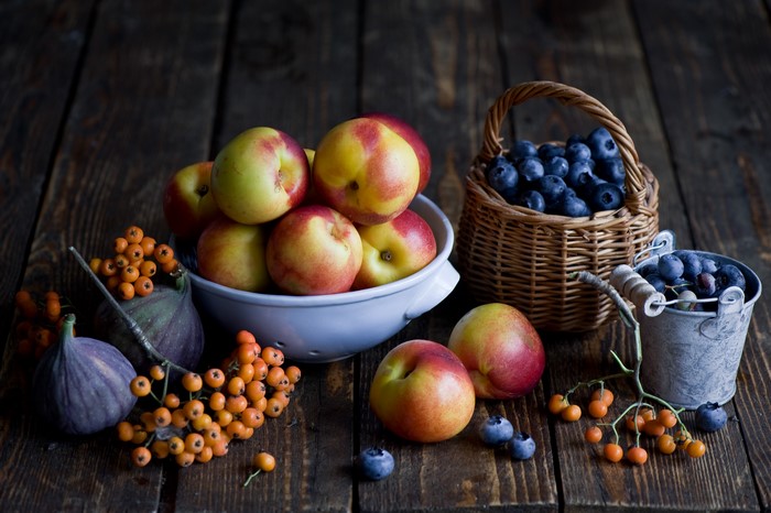 Still life with peaches, blueberries, figs, and berries