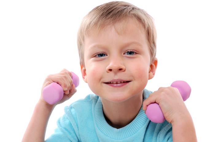 Boy with pink dumbbells on white background