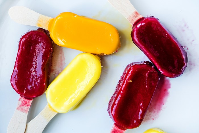 Four colorful ice pops on a white plate