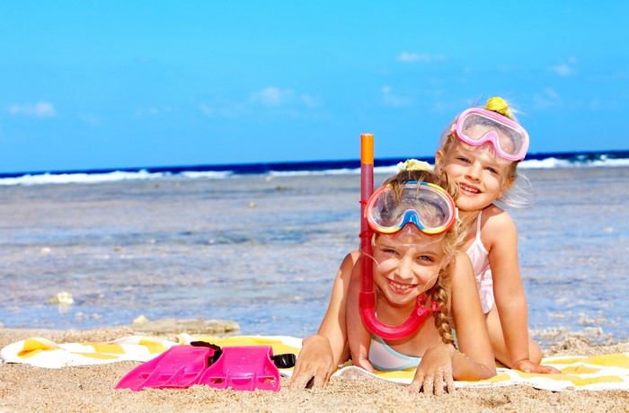 Two Smiling Little Girls on Sunny Beach with Snorkel Gear