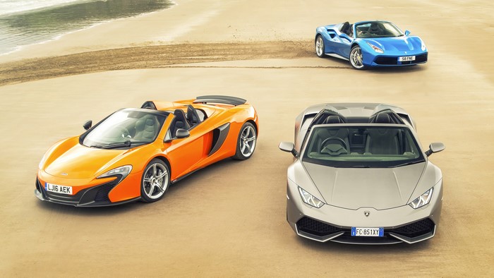 Three convertible sports cars on a beach