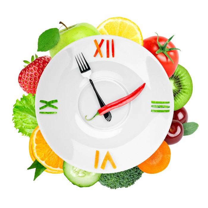 Clock made of fruits and vegetables on a plate
