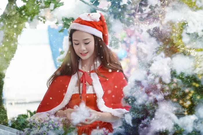 Asian woman in Santa costume with snow