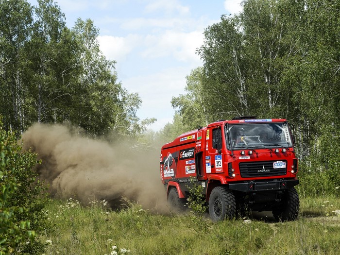 Red rally truck driving through a forest
