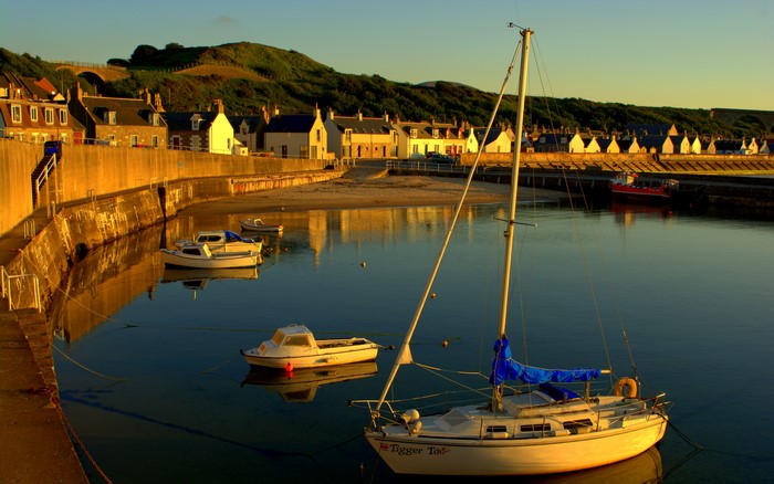 Cullen, Scotland harbor with boats and houses at sunset