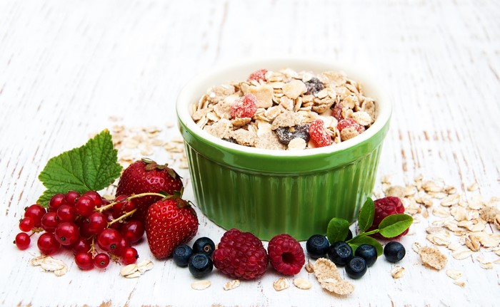 Muesli with fresh berries in a green bowl