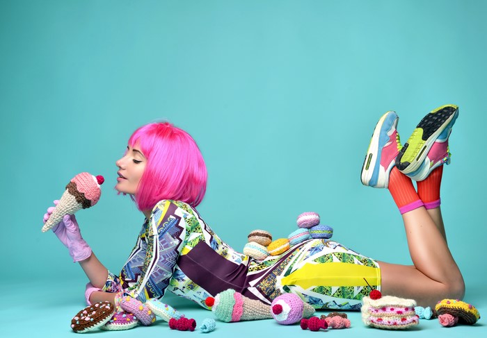 Woman in colorful dress with pink wig and ice cream props