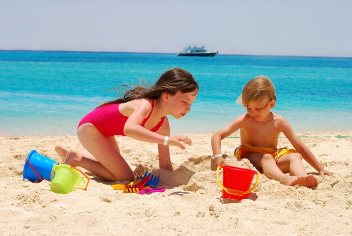 Children playing with sand toys on a beach