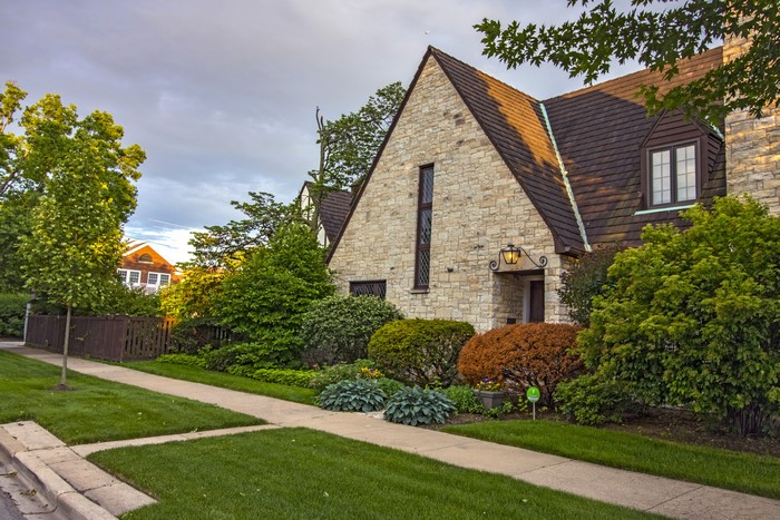 Stone house with manicured lawn and sidewalk