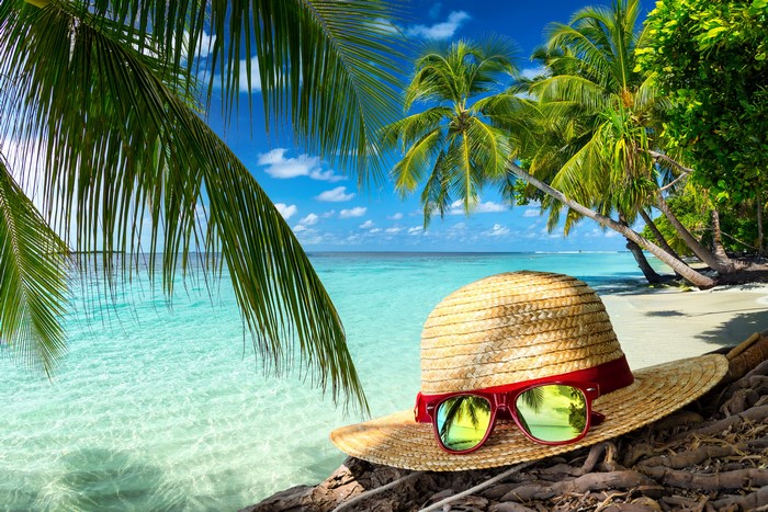 Summer beach with palm trees, hat, and sunglasses