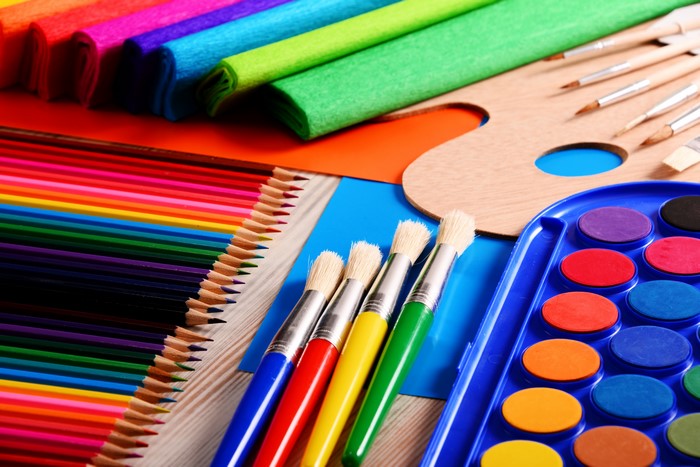 Art supplies: colored pencils, paintbrushes, watercolors, and paper