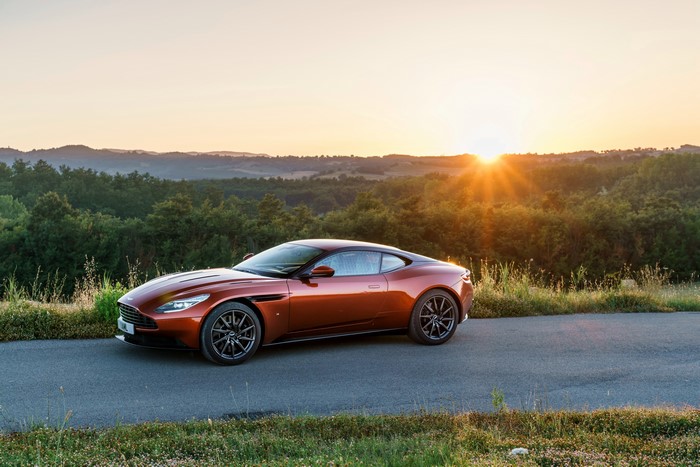 Aston Martin DB11 on a road at sunset