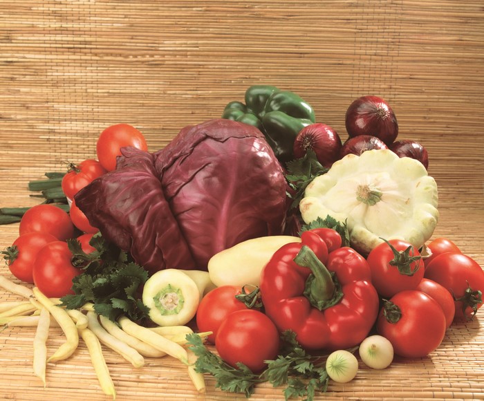 Assortment of fresh vegetables including tomatoes, peppers, cabbage, and onions